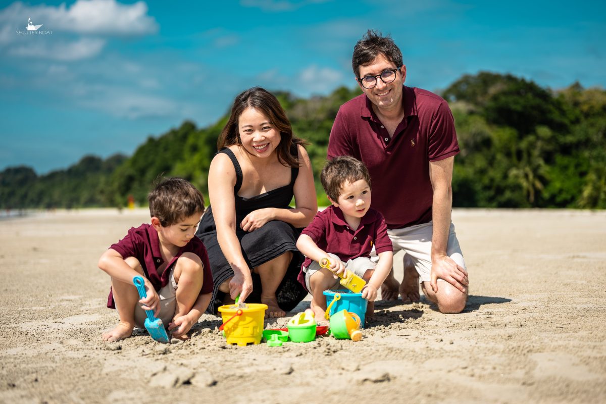 Family with two small boys playing in the sand on a beach