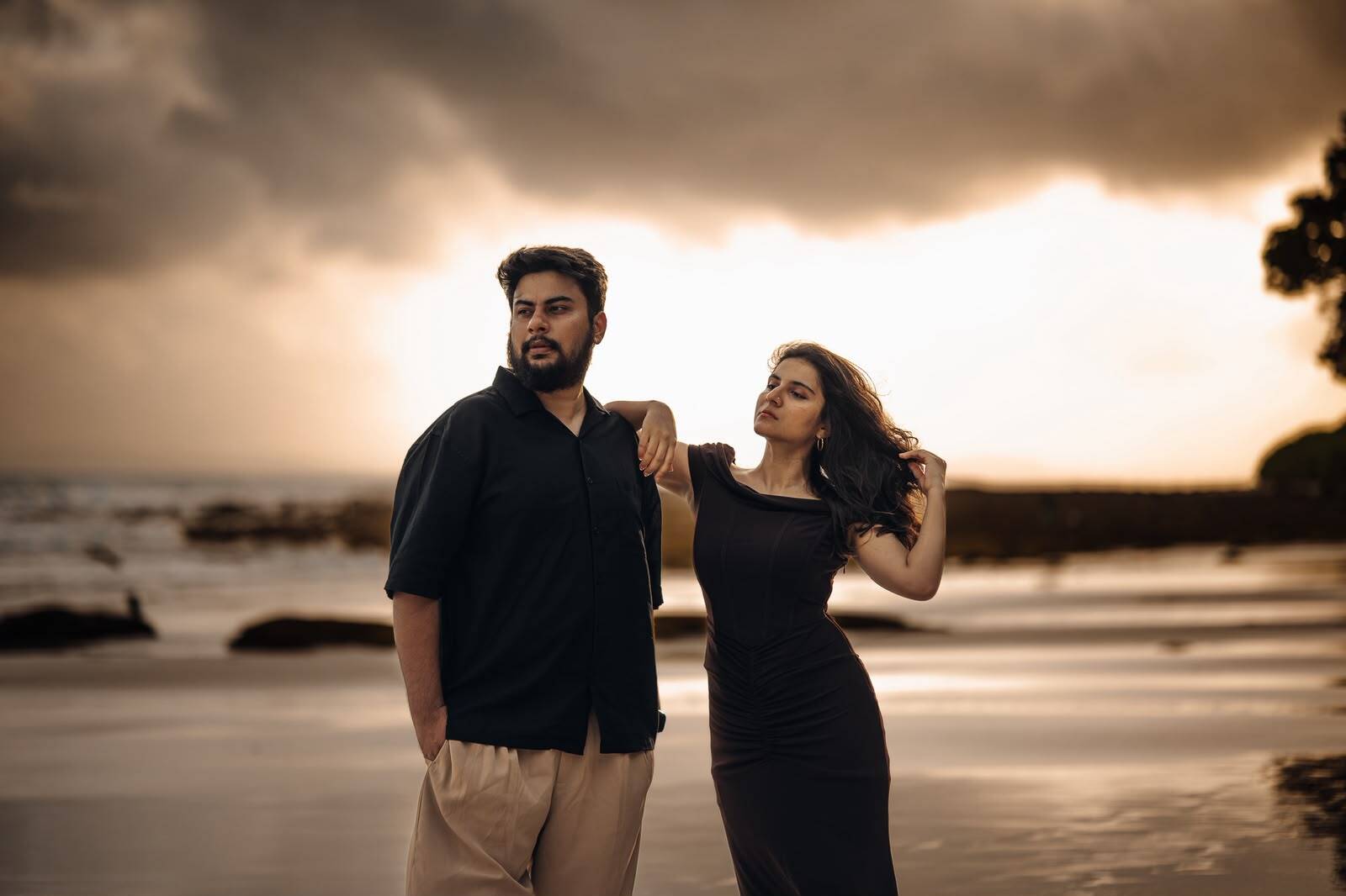 Couple on a Havelock beach beneath a golden cloudy sky